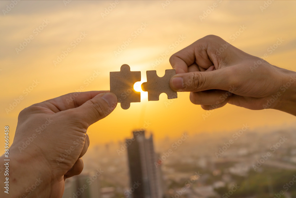 Closeup hand of connecting jigsaw puzzle with sunlight effect, Business solutions, success and strategy concept Closeup hand of connecting jigsaw puzzle with sunlight effect, Business solutions, success and strategy concept