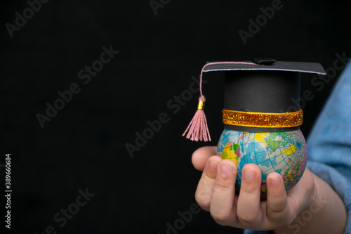 Education in Global world, Graduation cap on the girl's hand holding Earth globe model map with Radar background in hands. Concept of global business study, abroad educational, Back to School