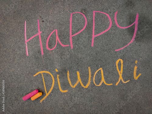 The inscription text on the grey board,Happy diwali. Using color chalk pieces.