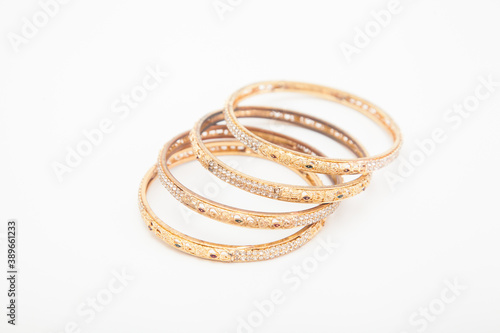 Set of golden bracelets on white background with selective focus