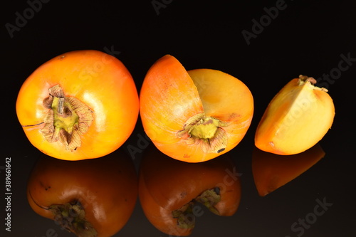 Ripe juicy organic persimmon, close-up, on a black background.