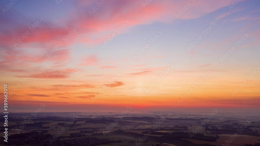 Cinematic hyperlapse with slow tilt upwards to reveal the colourful hues of the sunset sky overlying the Yorkshire countryside below. West Yorkshire, UK. Cinematic hyperlapse with slow tilt upwards to reveal the colourful hues of the sunset sky overlying the Yorkshire countryside below. West Yorkshire, UK.