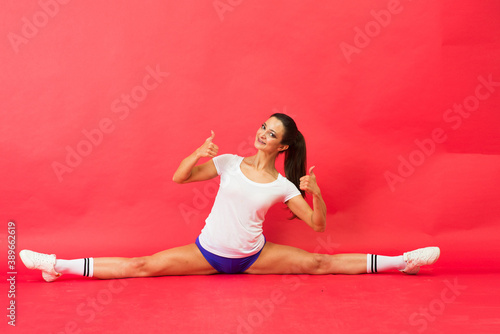 Beautiful young fit gymnast woman in sportswear working out, performing art gymnastics element