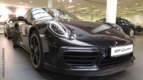 Moscow. February 2018. Black Porsche 911 991 Carrera  at dealer showroom. Headlights and aerodynamic turbo packed Front and side view