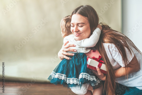 Mom hugs her baby daughter and is happy with the gift