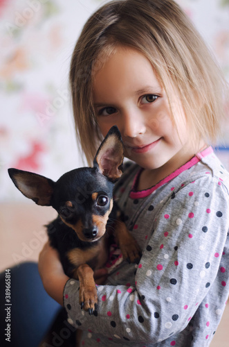 A little blond girl with her pet dog
