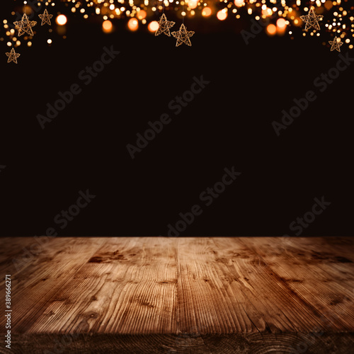 Wooden background with christmas stars Golden christmas stars and festive bokeh lights in front of illuminated rustic wooden square background for a christmas decoration. Space for text and design. 