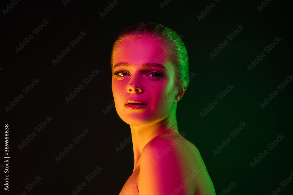 Inspired. Portrait of female fashion model in neon light on dark studio background. Beautiful caucasian woman with trendy make-up and well-kept skin. Vivid style, beauty concept. Close up. Copyspace Inspired. Portrait of female fashion model in neon light on dark studio background. Beautiful caucasian woman with trendy make-up and well-kept skin. Vivid style, beauty concept. Close up. Copyspace