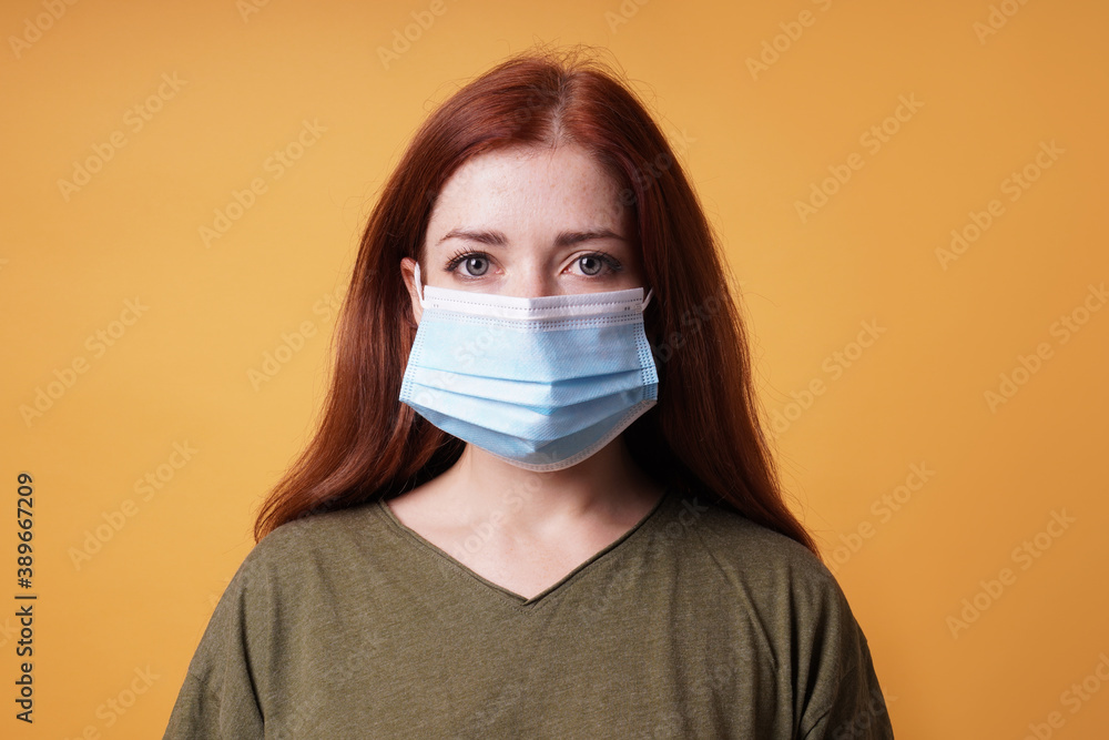 studio portrait of young woman wearing a medical face mask covering mouth and nose - protection against corona virus studio portrait of young woman wearing a medical face mask covering mouth and nose - protection against corona virus