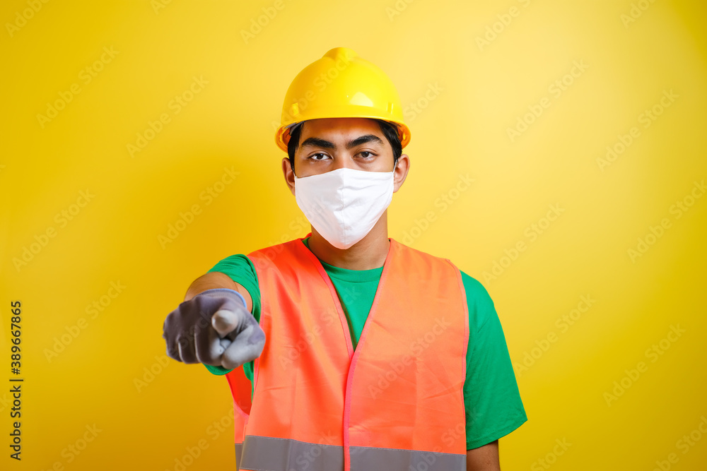 asian construction worker wearing protective mask pointing forward asian construction worker wearing protective mask pointing forward
