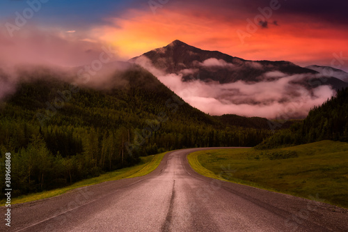 Beautiful View of a scenic road, Alaska Hwy, in the Northern Rockies during a sunny and cloudy morning sunrise. Dramatic Sky Artistic Render. Taken in British Columbia, Canada. Nature Background