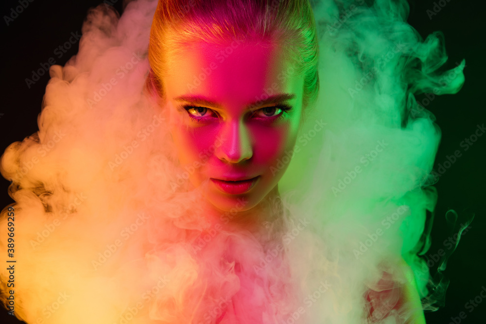 Fototapeta premium Passioned. Portrait of female fashion model in neon light on dark studio background with smoke. Beautiful caucasian woman with trendy make-up and well-kept skin. Vivid style, beauty concept. Close up.