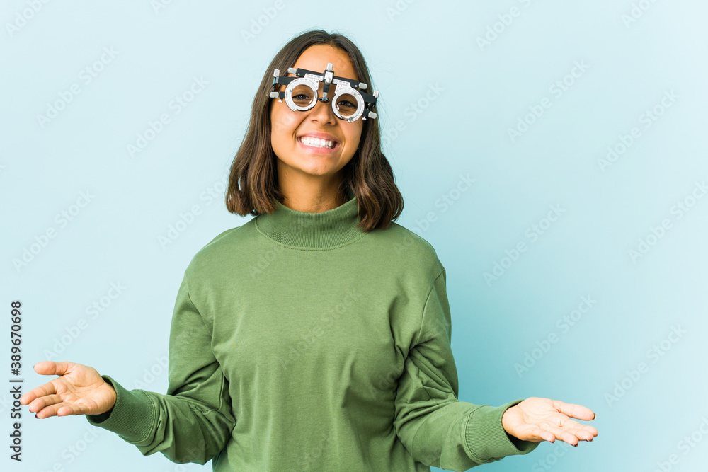 Young oculist latin woman over isolated background Young oculist latin woman over isolated background