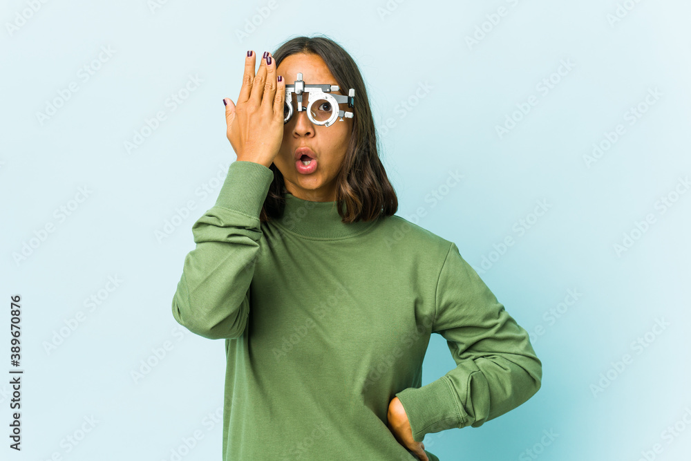 Young oculist latin woman over isolated background Young oculist latin woman over isolated background
