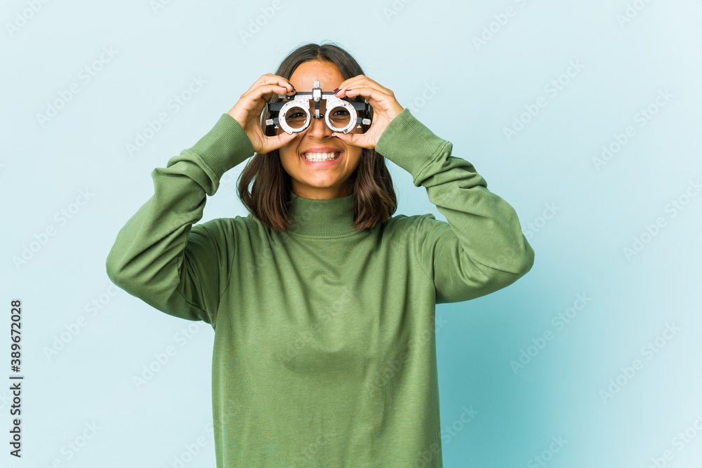 Young oculist latin woman over isolated background Young oculist latin woman over isolated background