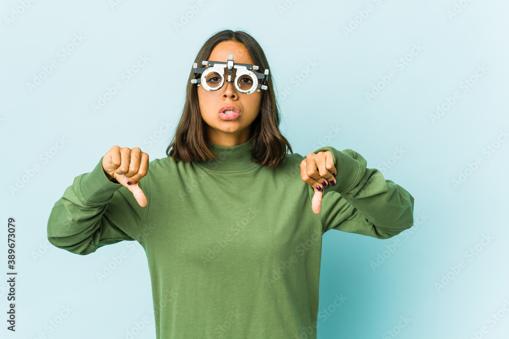 Young oculist latin woman over isolated background Young oculist latin woman over isolated background