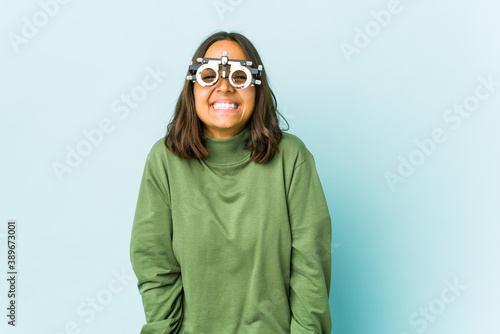 Young oculist latin woman over isolated background