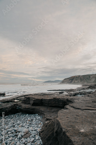 beach of rocks and black sand during sunset in winter