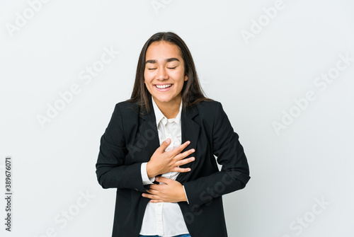 Young asian bussines woman isolated on white background laughs happily and has fun keeping hands on stomach.