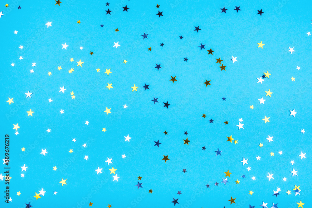 Golden and silver stars on blue pastel background. Flat lay, top view. Golden and silver stars on blue pastel background. Flat lay, top view.
