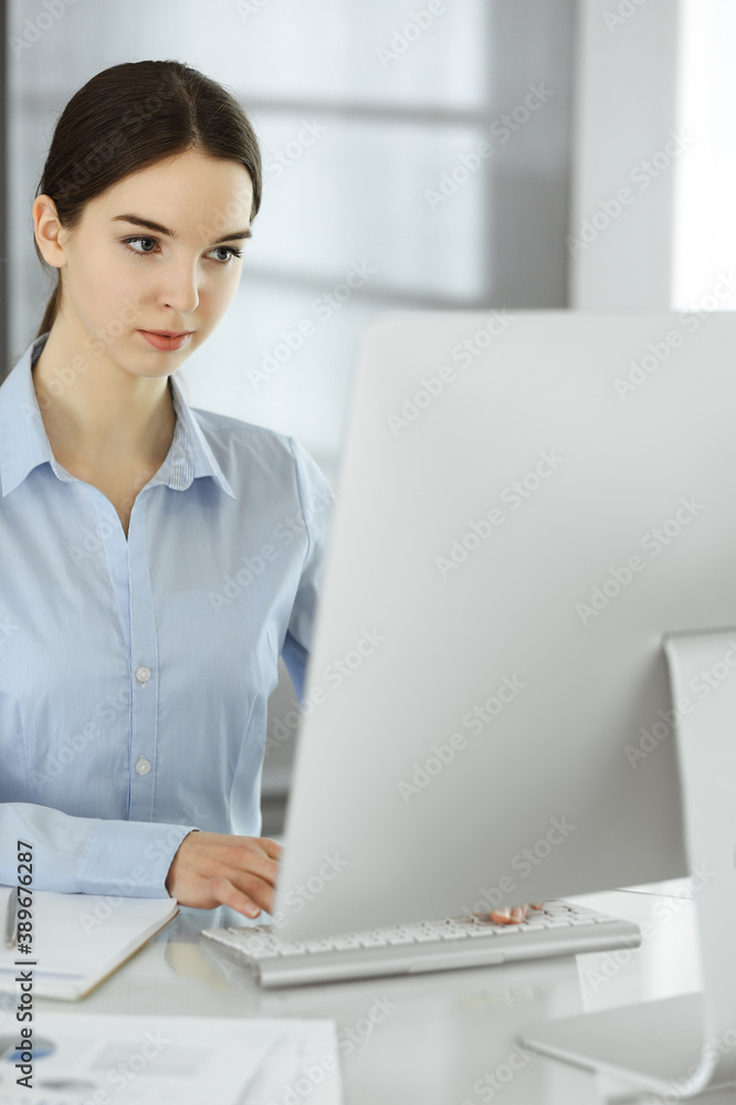 Business woman working with computer at the glass desk in modern office. Student girl preparing presentation or bookkeeper making balance. Tax and audit concept Business woman working with computer at the glass desk in modern office. Student girl preparing presentation or bookkeeper making balance. Tax and audit concept