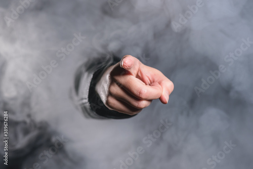 A person is showing ahead by her index finger through the smoke.