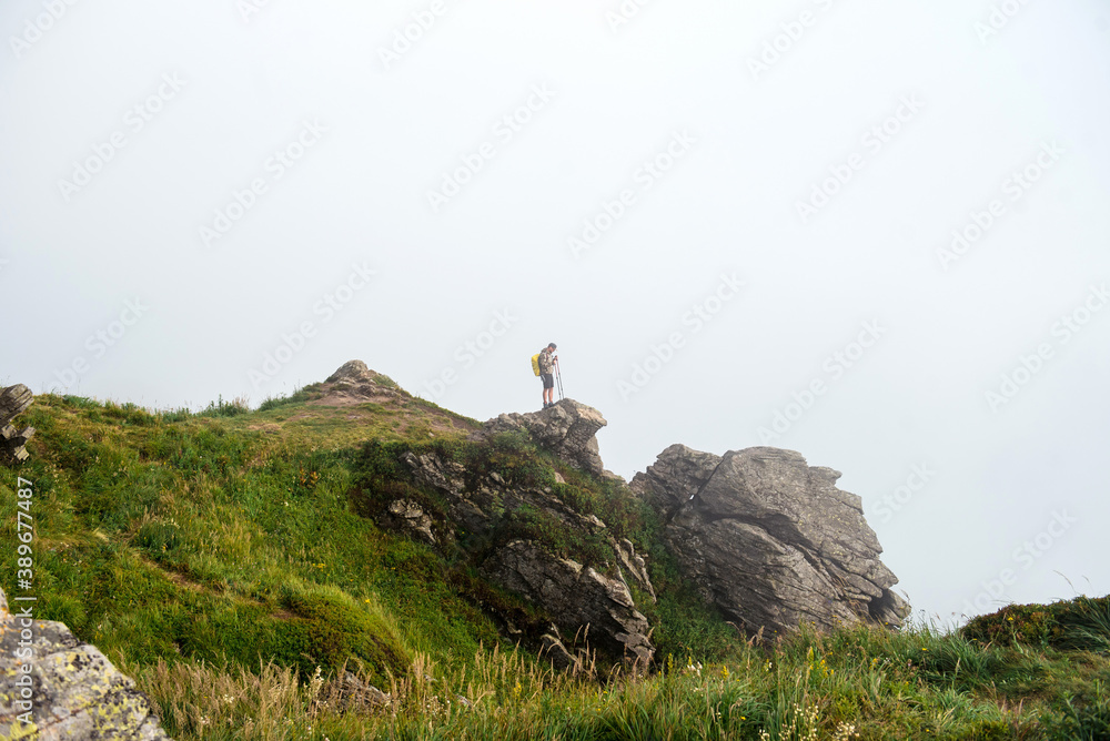 Man standing high on rock and enjoying view of mountains
