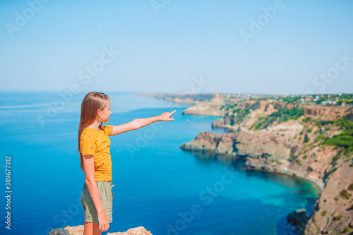 Happy kid outdoor on edge of cliff seashore