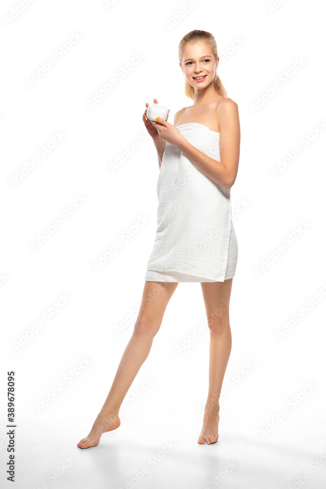 Moisturizer. Beautiful female model isolated on white background. Beauty, cosmetics, spa, depilation, diet and treatment, fitness concept. Fit and sportive, sensual body with well-kept skin in towel. Moisturizer. Beautiful female model isolated on white background. Beauty, cosmetics, spa, depilation, diet and treatment, fitness concept. Fit and sportive, sensual body with well-kept skin in towel.