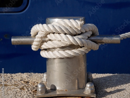 Metal bollard for ship mooring on a blue background