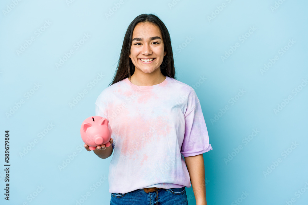 Young asian woman holding a pink bank over isolated background happy, smiling and cheerful. Young asian woman holding a pink bank over isolated background happy, smiling and cheerful.
