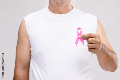 Breast cancer in men concept : Portrait Asian man and pink ribbon the symbol of breast cancer campaign. Studio shot isolated on grey