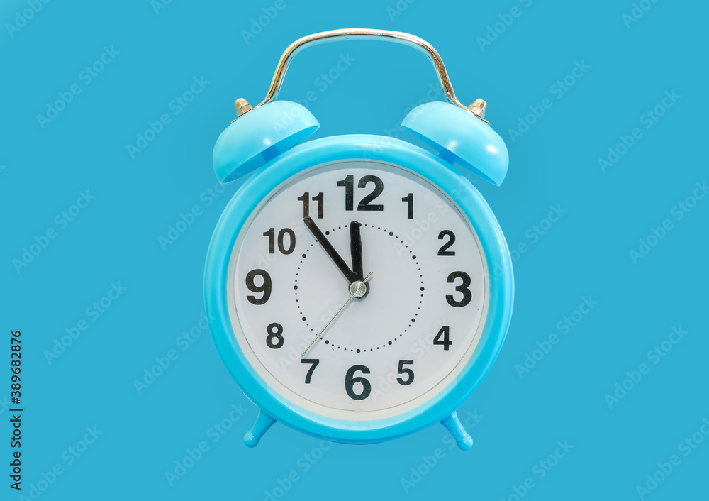 blue alarm clock isolated on blue background. 23.55 on the alarm clock. Almost midnight. blue alarm clock isolated on blue background. 23.55 on the alarm clock. Almost midnight.