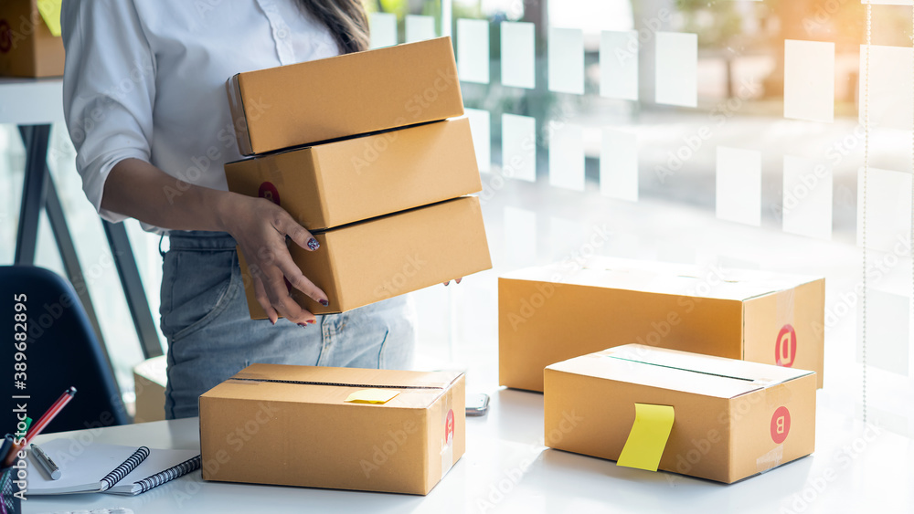 A girl with a box in hand and a box placed next to the idea of selling things online. A girl with a box in hand and a box placed next to the idea of selling things online.