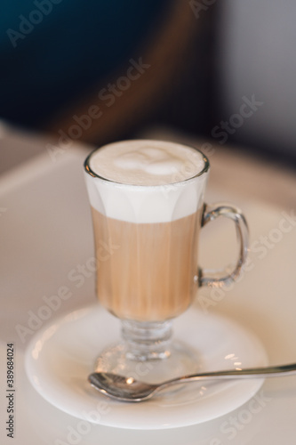 A Glass of hot cappuccino coffee on the table in cafe shop with breakfast background. vintage film color tone.