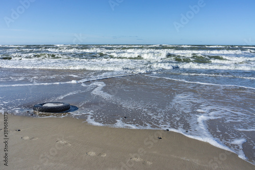 Wallpaper Mural Car tire on the seashore. small waves on the sea. ships on the sea horizon. Baltic sea coast. Torontodigital.ca