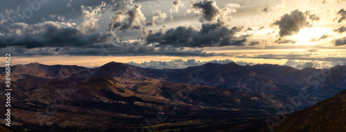 Aerial Panoramic View of Scenic Landscape and Mountains on a Cloudy Fall Season in Canadian Nature. Colorful Sunrise Sky Artistic Render. Taken in Tombstone Territorial Park, Yukon, Canada.
