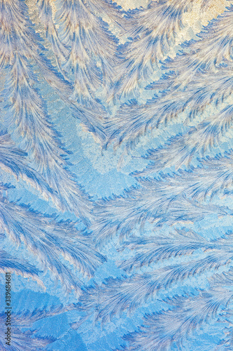 Frost forms in patterns on window glass on a cold winter morning