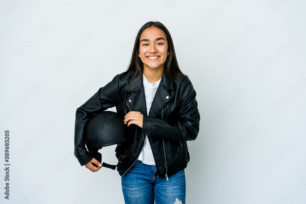 Young asian woman holding a motorbike helmet over isolated background laughing and having fun. Young asian woman holding a motorbike helmet over isolated background laughing and having fun.
