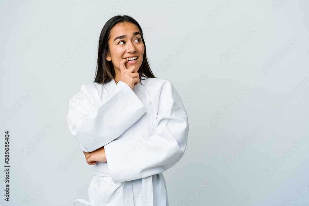 Young asian woman doing karate isolated on white background relaxed thinking about something looking at a copy space. Young asian woman doing karate isolated on white background relaxed thinking about something looking at a copy space.