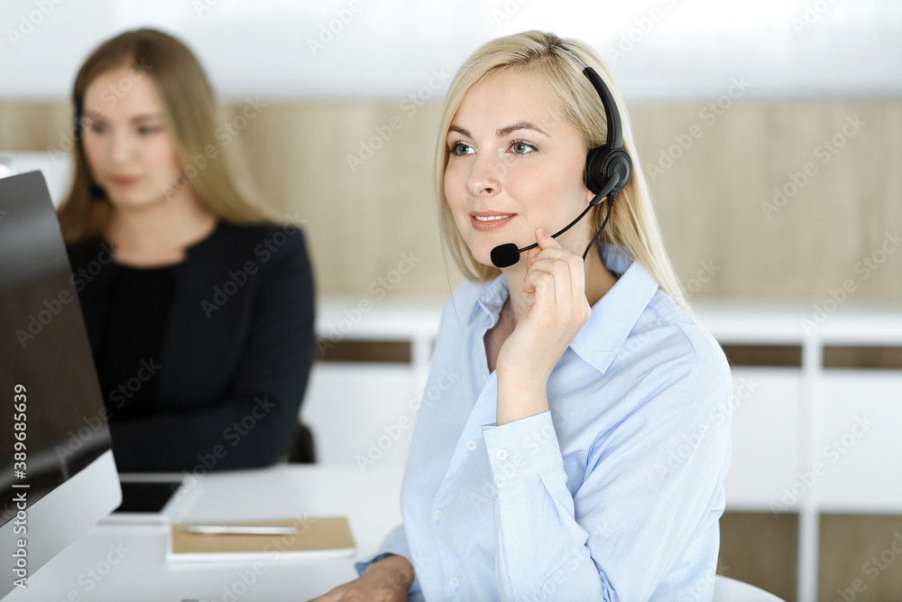 Blonde business woman sitting and communicated by headset in call center office. Concept of telesales business Blonde business woman sitting and communicated by headset in call center office. Concept of telesales business