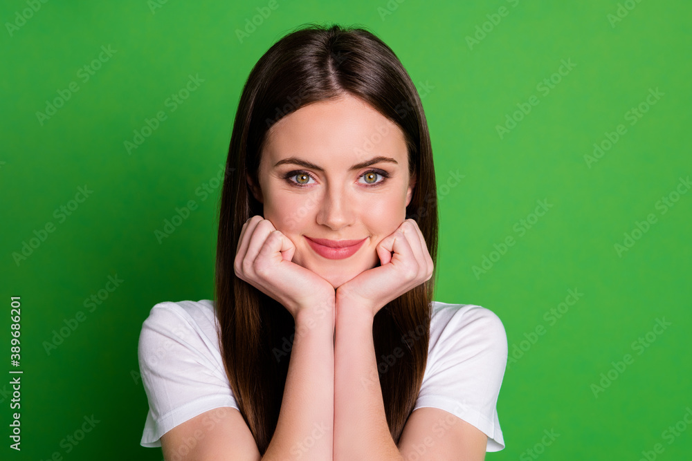 Photo portrait of cute girl holding head face with two hands isolated on vivid green colored background Photo portrait of cute girl holding head face with two hands isolated on vivid green colored background