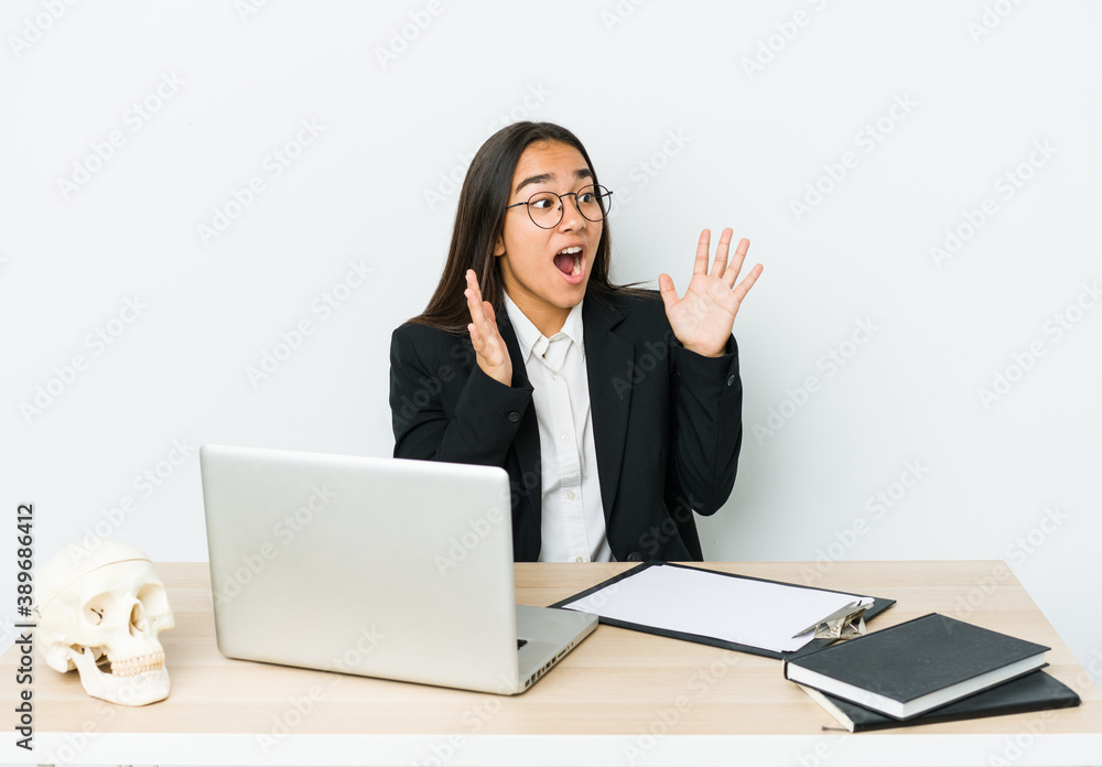 Young traumatologist asian woman isolated on white background shouts loud, keeps eyes opened and hands tense. Young traumatologist asian woman isolated on white background shouts loud, keeps eyes opened and hands tense.