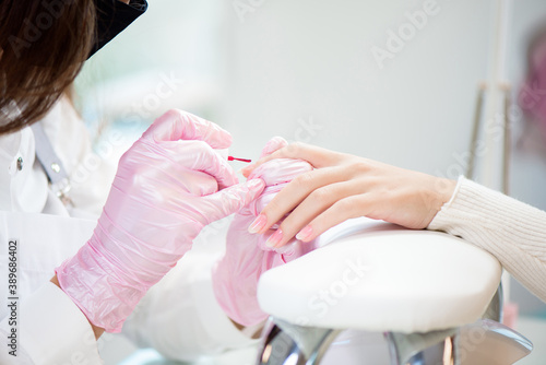 Hands in gloves cares about hand nails. Manicure beauty salon.