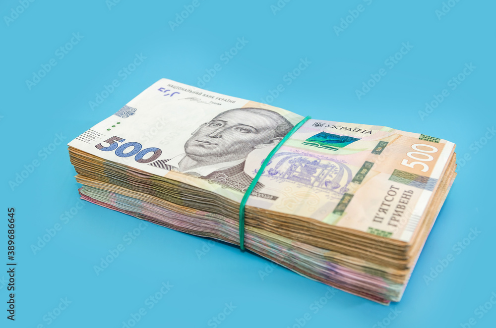 stack with 500 hryvnia on a blue background. Ukrainian money isolated on blue. Financial concept. New banknotes. stack with 500 hryvnia on a blue background. Ukrainian money isolated on blue. Financial concept. New banknotes.
