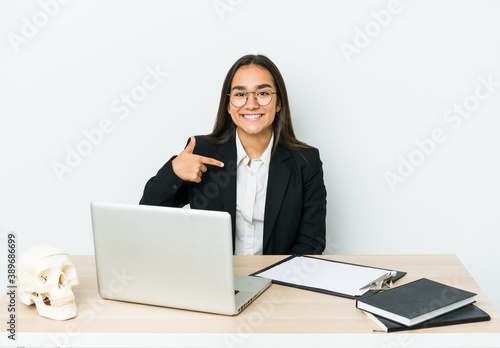 Young traumatologist asian woman isolated on white background person pointing by hand to a shirt copy space, proud and confident © Asier