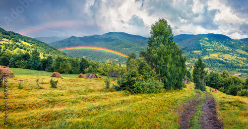 Double rainbow at the summer rain. Gorgeous evening view of Kvasy village, Transcarpathian, Ukraine. Picturesque landscape of Carpathian mountains. Beauty of countryside concept background. photo