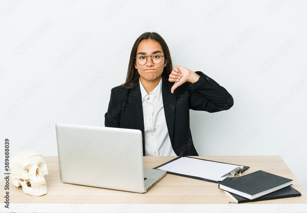 Young traumatologist asian woman isolated on white background showing a dislike gesture, thumbs down. Disagreement concept. Young traumatologist asian woman isolated on white background showing a dislike gesture, thumbs down. Disagreement concept.