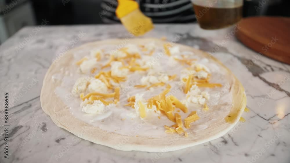 Chef spreading sour cream and cheese over pizza dough, cooking italian pizza. Tasty traditional street fast food, high kitchen restaurant Chef spreading sour cream and cheese over pizza dough, cooking italian pizza. Tasty traditional street fast food, high kitchen restaurant