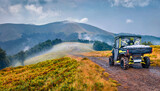 Traveling by all-terrain vehicle on the mountains. Off-road tour in Carpathian mountains, Ukraine, Europe. Foggy summer view of Krasna range. Traveling concept background..